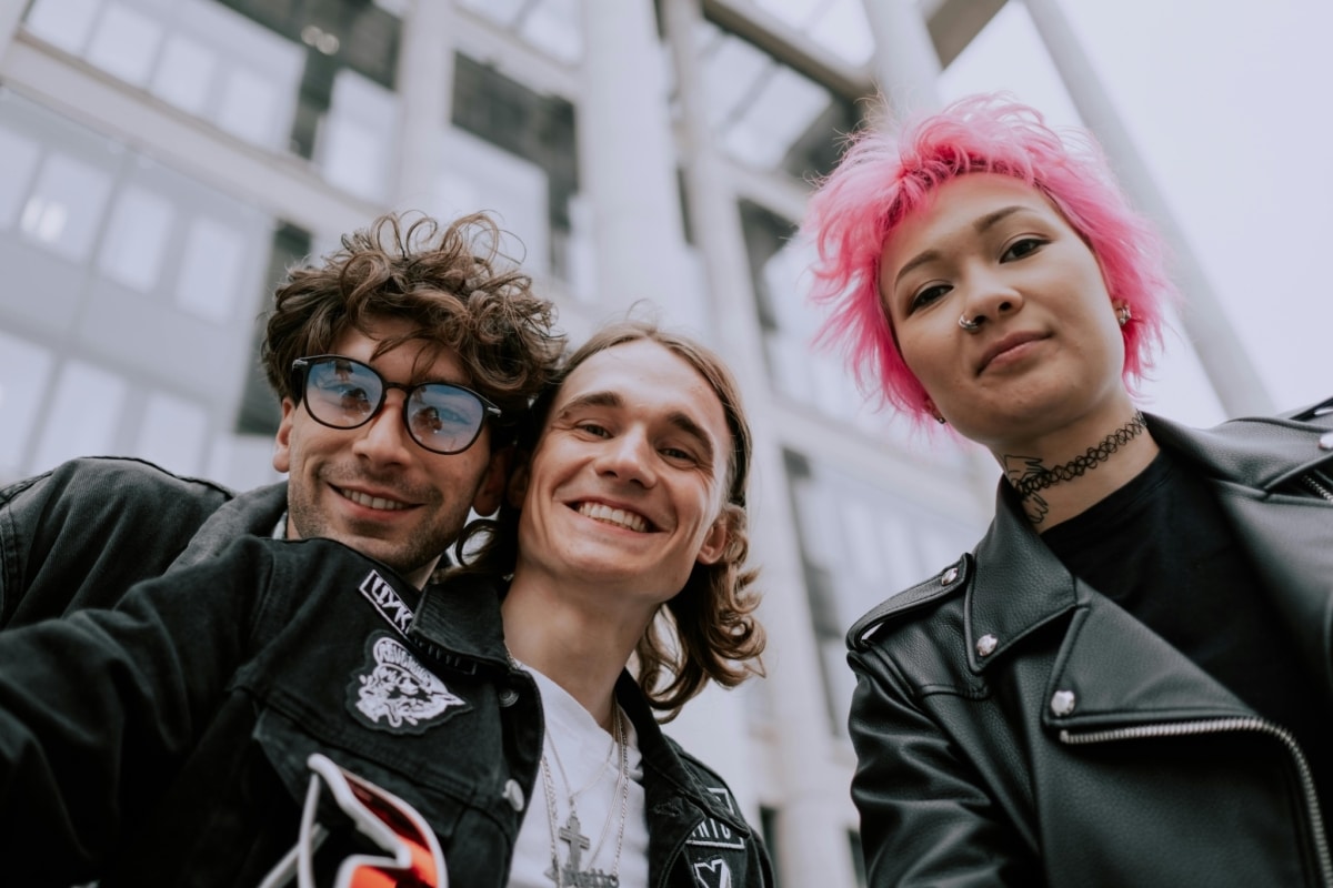 3 Young People Smiling At Camera